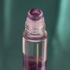 Roll-on aux huiles essentielles avec bille applicatrice et pierre naturelle d’améthyste.