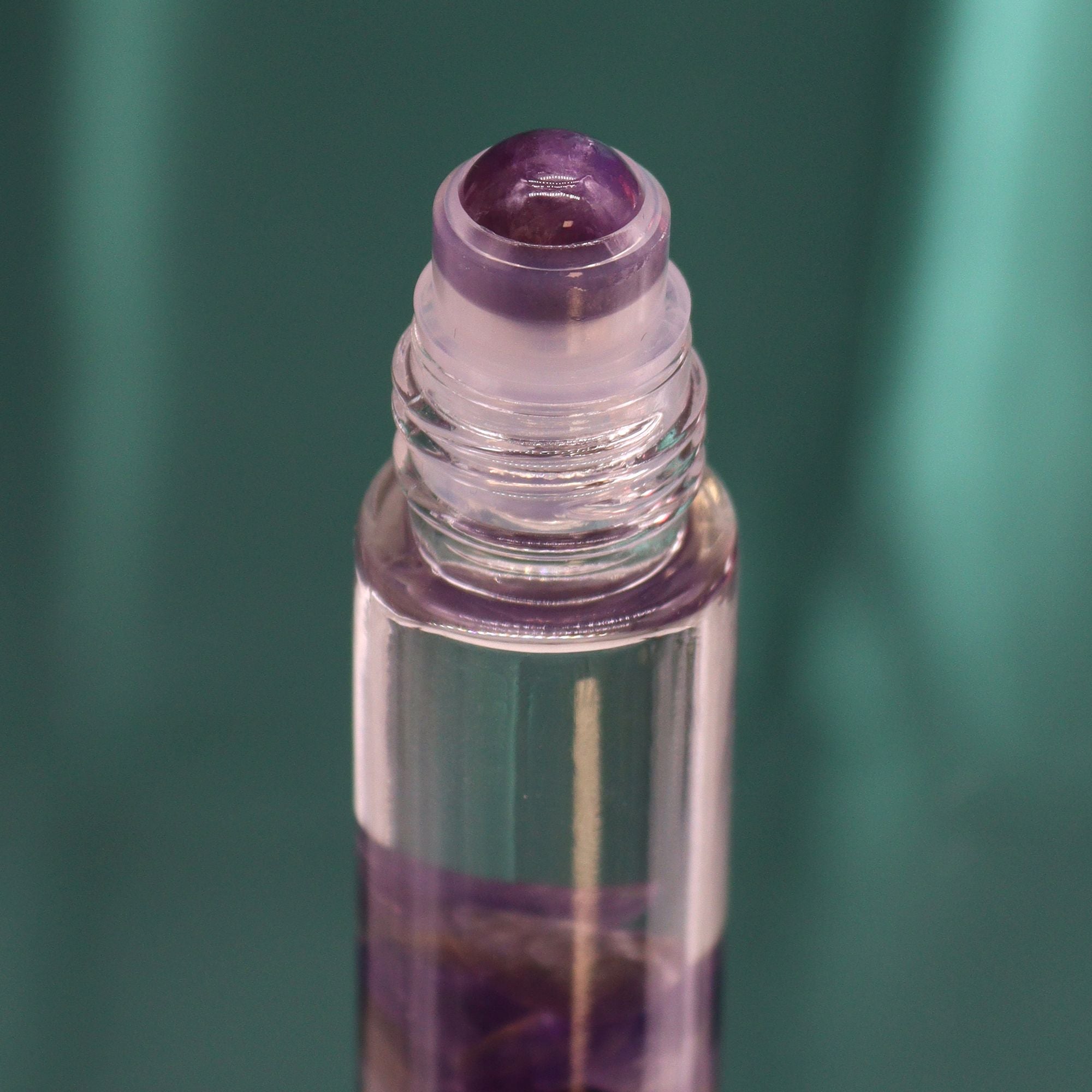 Roll-on aux huiles essentielles avec bille applicatrice et pierre naturelle d’améthyste.