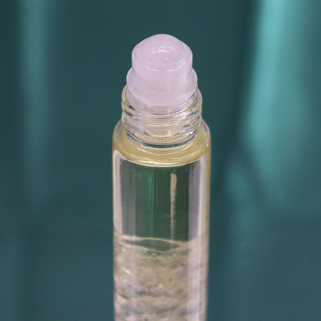 Roll-on aux huiles essentielles avec bille applicatrice et pierre naturelle de quartz.