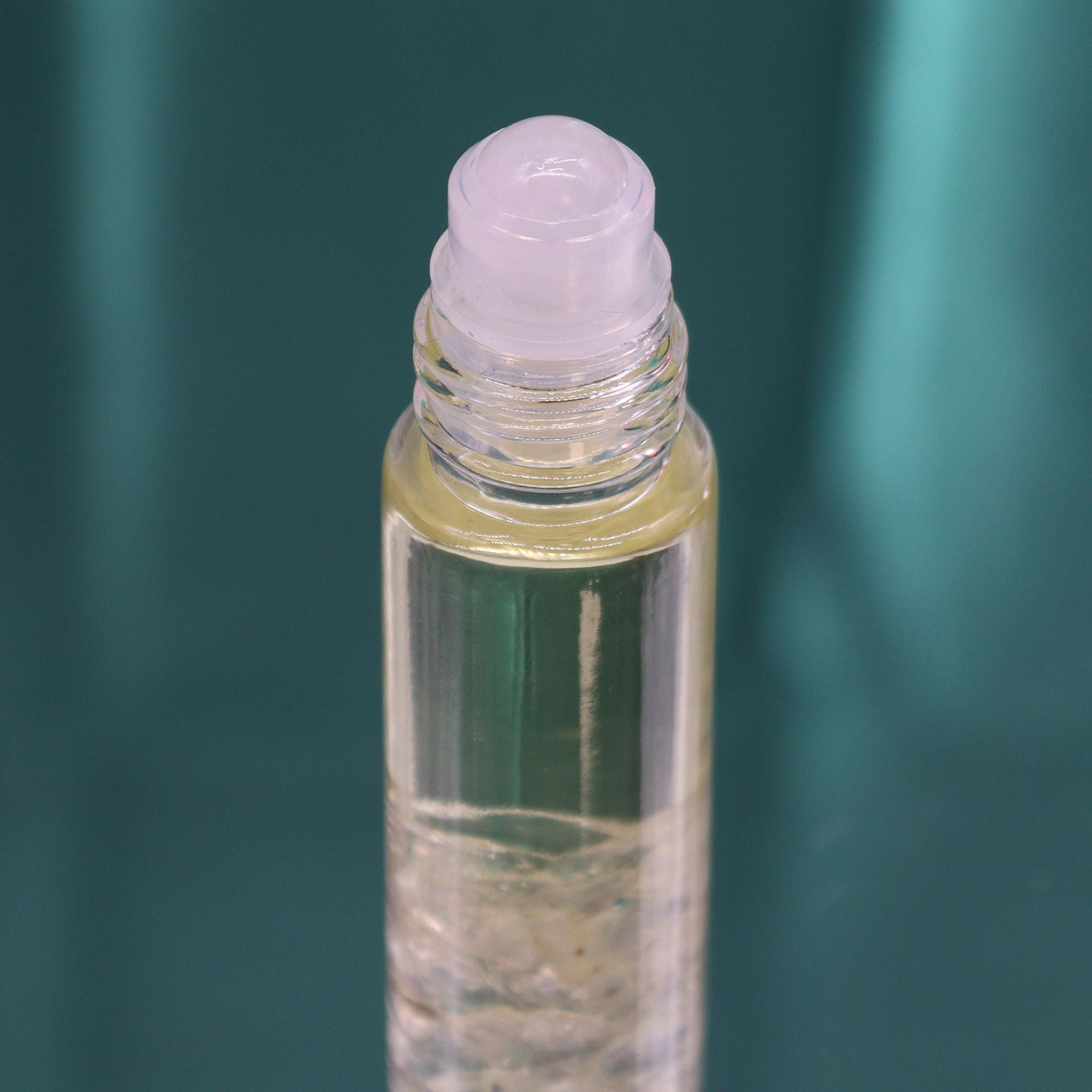 Roll-on aux huiles essentielles avec bille applicatrice et pierre naturelle de quartz.