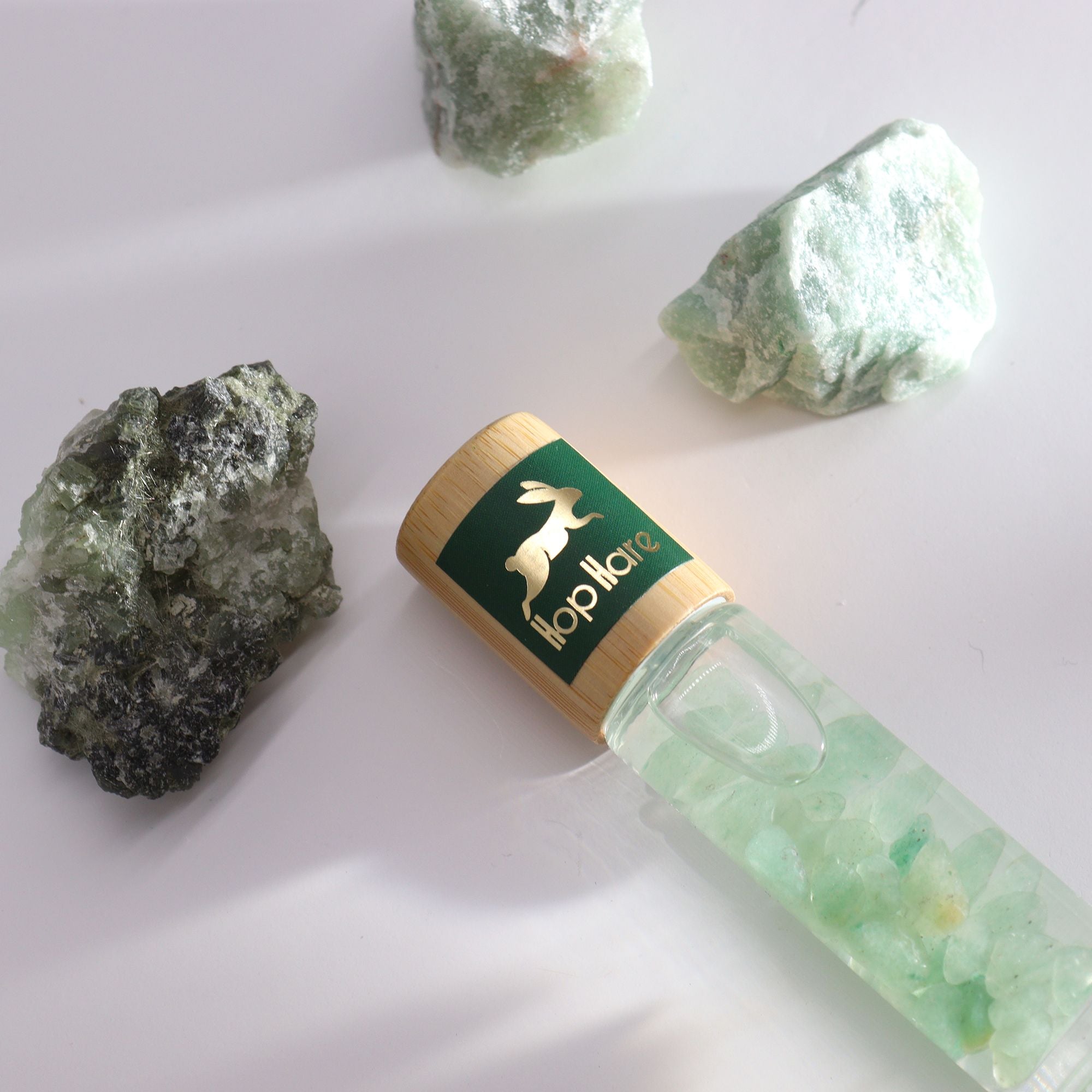 Roll-on aux huiles essentielles avec bille applicatrice entouré de pierre naturelle d’aventurine.