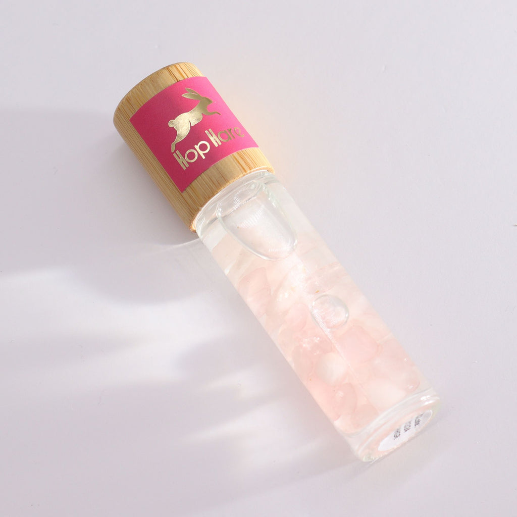 Roll-on aux huiles essentielles avec bille applicatrice et pierre naturelle de quartz rose.