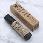Roll-on d’huiles essentielles calme 10 ml posé avec son étui carton sur fond clair – mélange aromathérapie relaxation