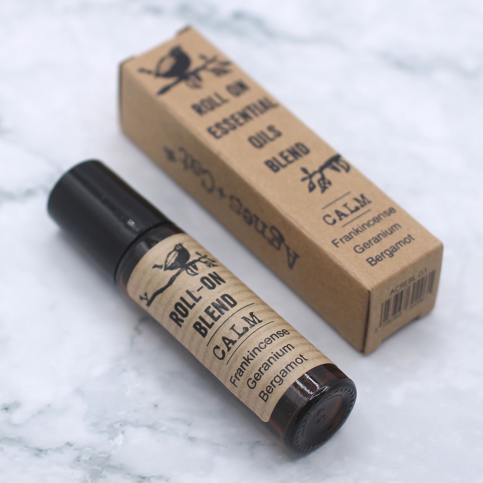 Roll-on d’huiles essentielles calme 10 ml posé avec son étui carton sur fond clair – mélange aromathérapie relaxation