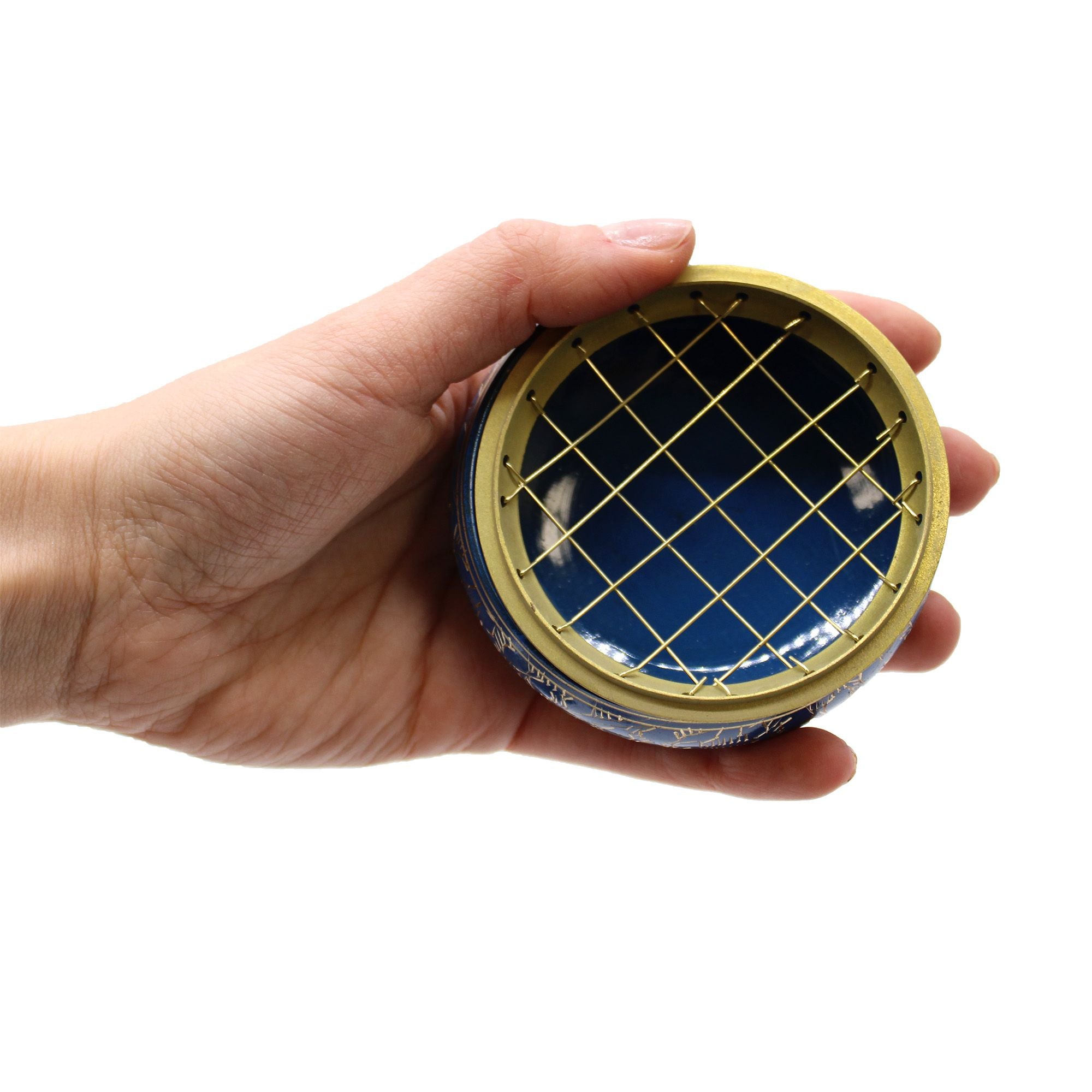 Main tenant un brûleur d’encens bleu et or au charbon en laiton, utilisation lors d’un rituel énergétique chakra 3ème oeil
